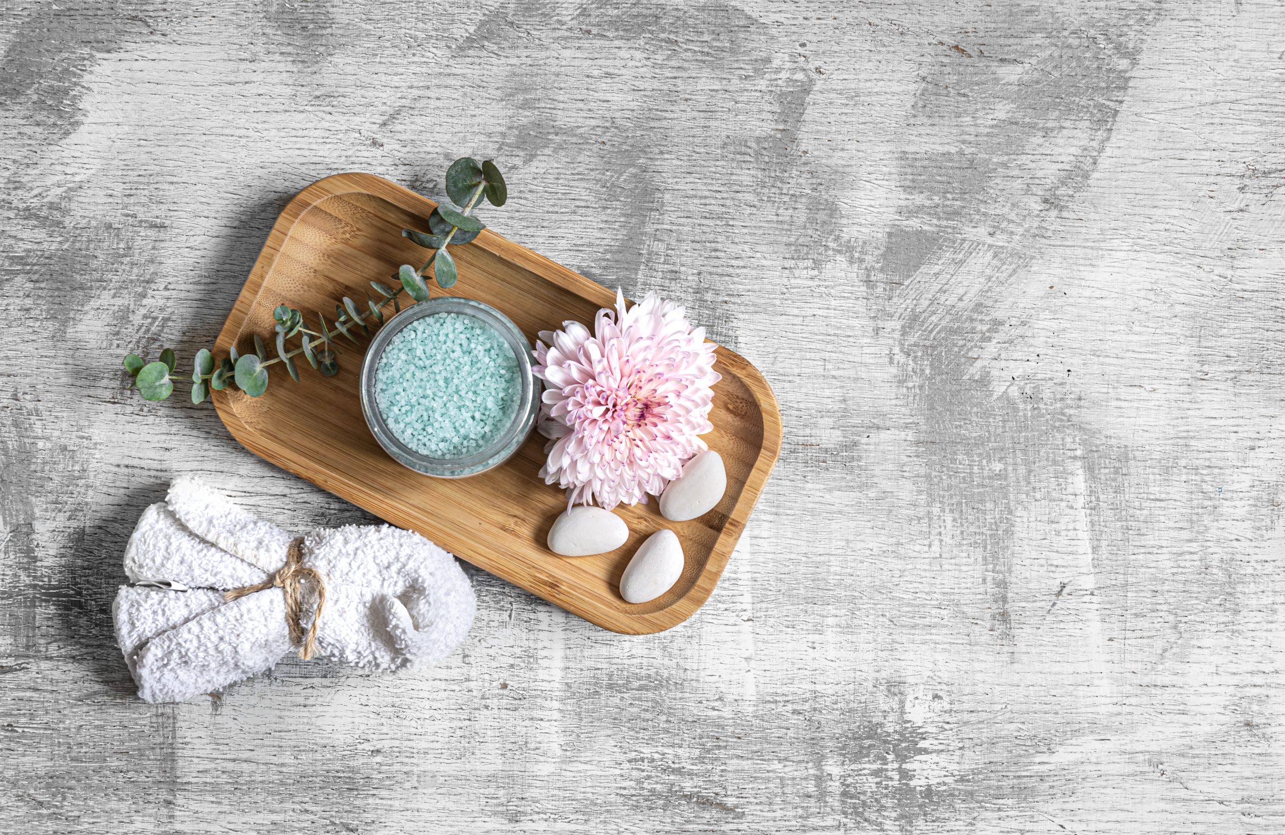 Flat lay spa composition with body products on textured concrete background, copy space.